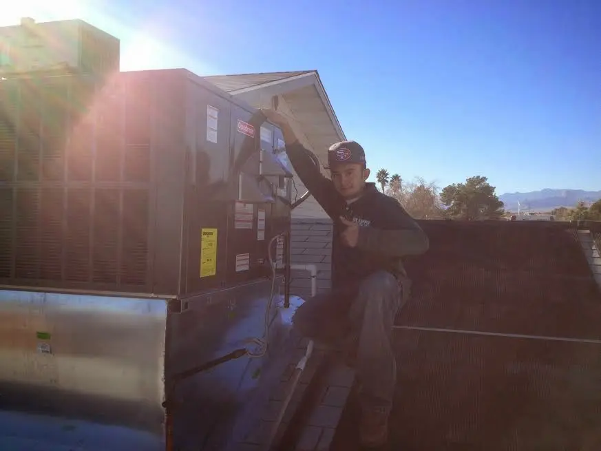 HVAC technician performing AC Tune-Up on a rooftop unit in Dana Point